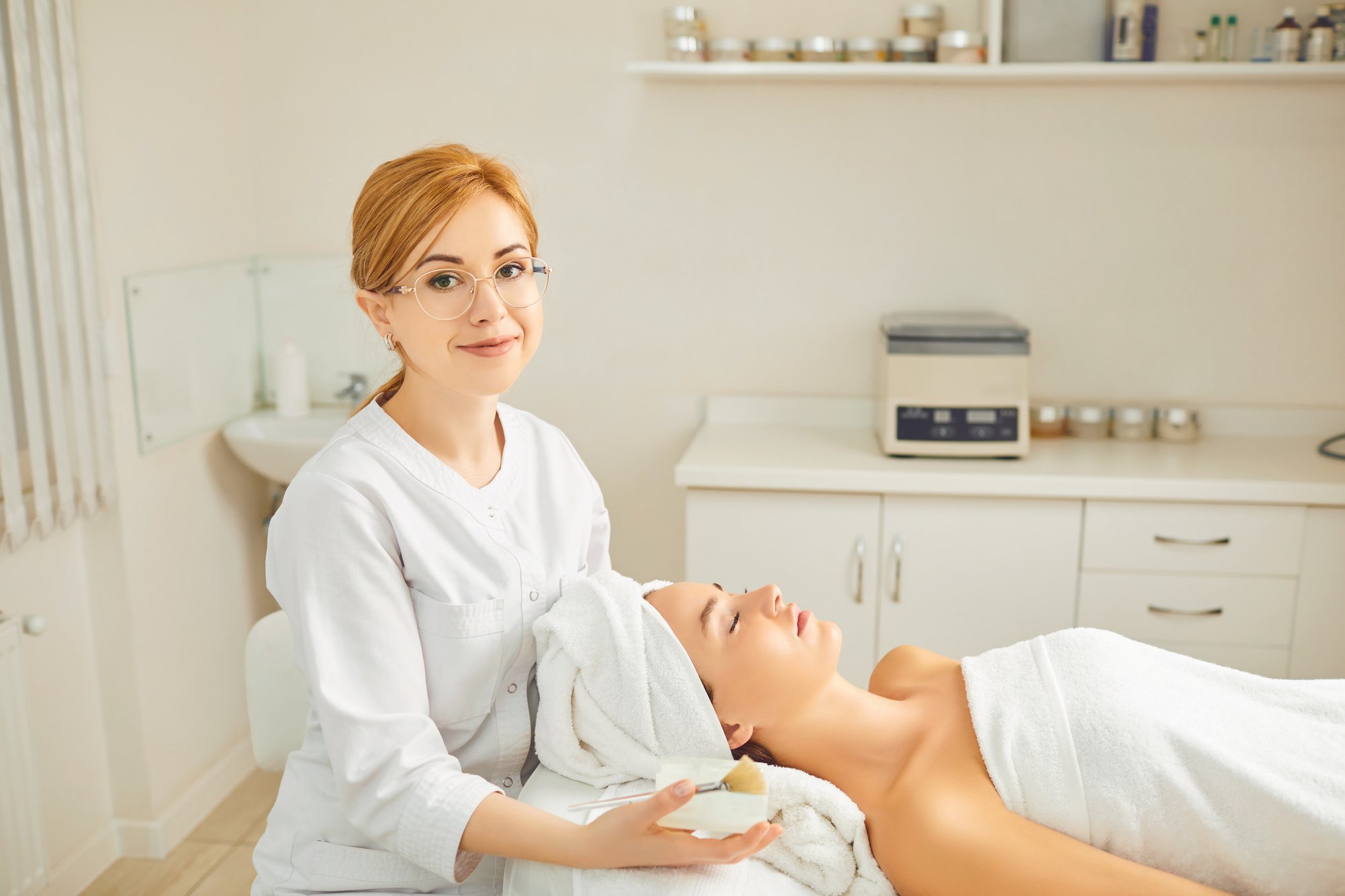 A Cosmetologist Makes a Face Mask to a Patient